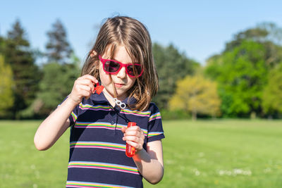 Portrait of smiling girl wearing sunglasses standing outdoors