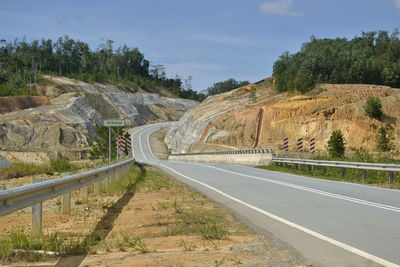 Road by mountain against sky