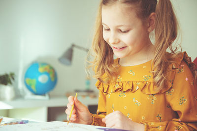 Cute girl painting while sitting at home