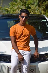 Portrait of young man standing in car