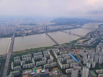 High angle view of river amidst buildings against sky
