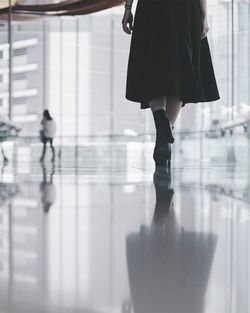 Low section of woman walking with reflection