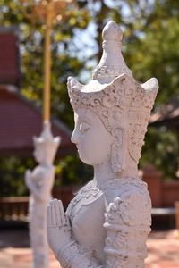 Close-up of angel statue against temple building