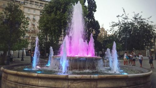 People on fountain against trees