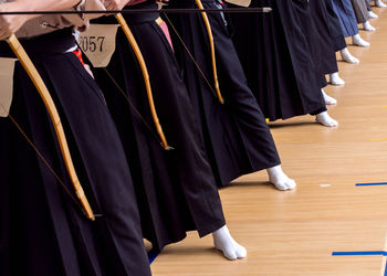 Low section of people standing on hardwood floor