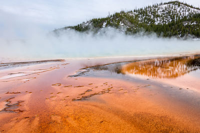 Scenic view of hot spring against sky