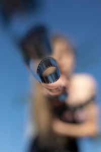 Defocused image of woman holding film reel against sky
