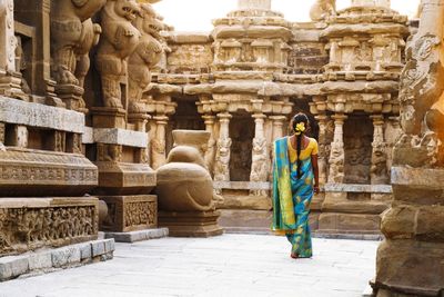 Rear view of woman walking in temple