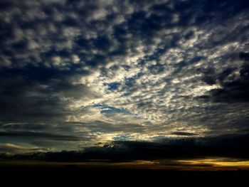 Scenic view of dramatic sky over silhouette landscape