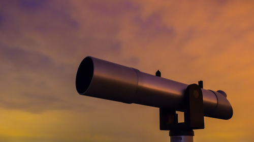 Close-up of coin-operated binoculars against sky during sunset