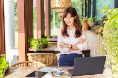 Young woman using mobile phone at table