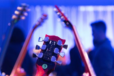 Close-up of guitar tuning pegs against musicians