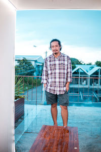 Portrait of smiling young man standing in swimming pool