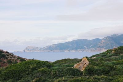 Scenic view of sea and mountains against sky