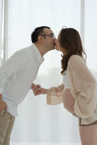 Side view of couple holding hands at office