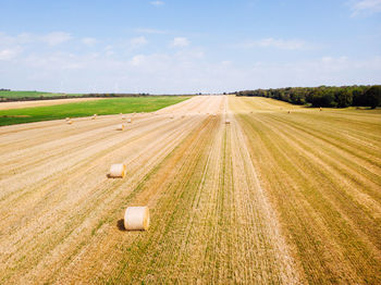 Aerial view of a harvested field. haystacks in a meadow and windmills. 