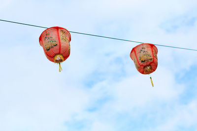 Low angle view of red lanterns hanging against sky