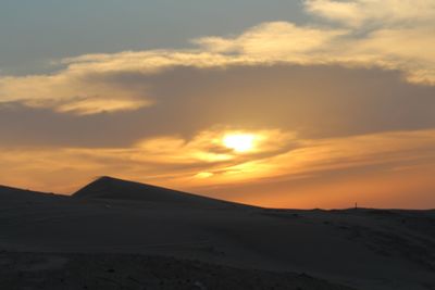 Scenic view of desert against sky during sunset
