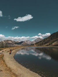 Scenic view of lake by mountains against sky