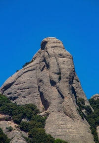 Low angle view of rock formation against blue sky