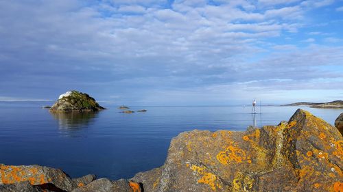 Scenic view of rocks in sea against sky