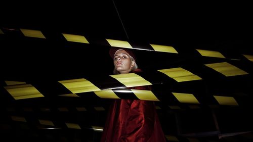 Low angle view of man standing in illuminated room