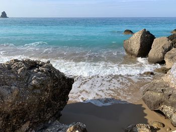 Rock formation on beach against sky