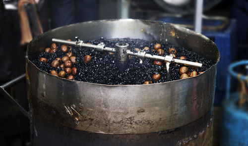 Chestnuts being roasted in a open hot stone pot and sold as street foods in kuala lumpur market