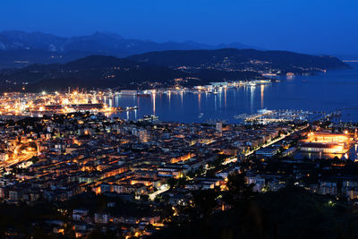 High angle view of city lit up at night