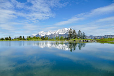 Scenic view of lake by trees against sky