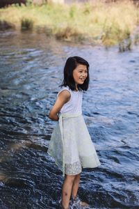 Smiling cute girl woman standing in lake 