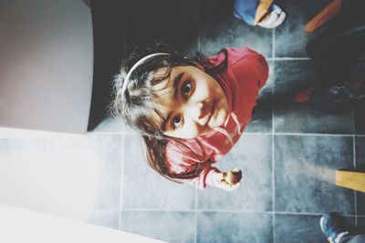 Directly above portrait of girl standing at home