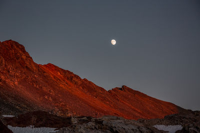 Low angle view of snowcapped mountains against clear sky at night