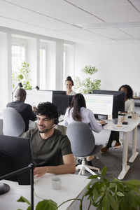 Man wearing headset using desktop pc in office