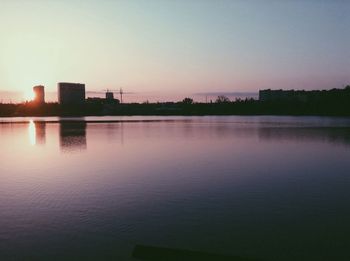 Scenic view of river against sky at sunset