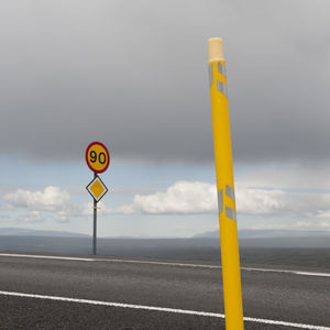 Close-up of road sign against sky