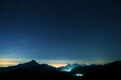 Silhouette rocky mountains against starry sky