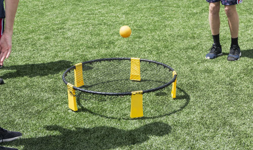 Low section of man playing with ball on trampoline