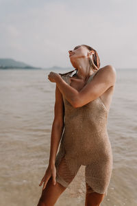 Midsection of woman standing at beach