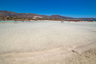 Scenic view of beach against clear blue sky