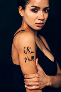 Midsection of woman with text on arm