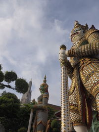 Low angle view of statues on building against sky