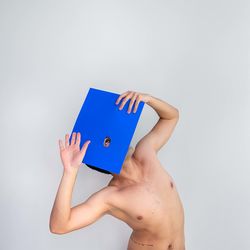 Cropped hands of woman holding paper against white background