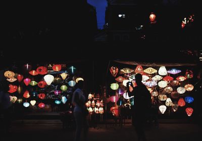 Men in illuminated traditional clothing at night
