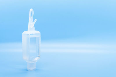 Close-up of glass bottle on table against blue background