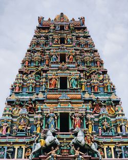 Low angle view of statues on building against sky