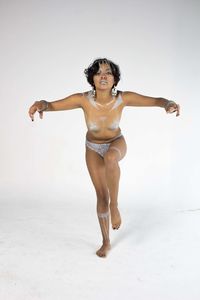 Full length of young woman standing against white background