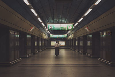 Rear view of woman standing at subway station