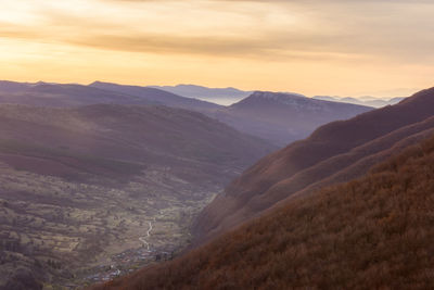 Scenic view of dramatic landscape against sky during sunset