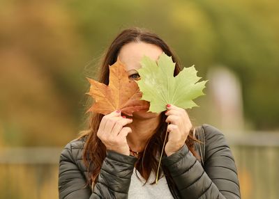 Portrait of woman holding leaves outdoors